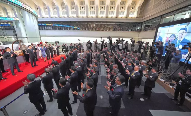 Participants perform a traditional hand clap at the end of a ceremony to conclude the year's trading at the Tokyo Stock Exchange Tuesday, Dec. 30, 2025, in Tokyo. (AP Photo/Eugene Hoshiko)