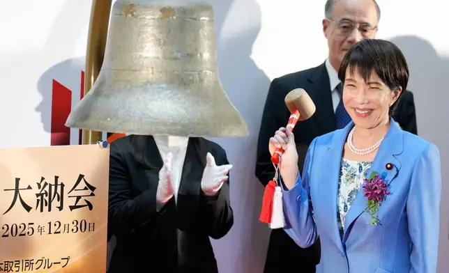 Japan's Prime Minister Sanae Takaichi poses before ringing the bell during a ceremony to mark the last trading day of the year on the Tokyo Stock Exchange Tuesday, Dec. 30, 2025, in Tokyo. (AP Photo/Eugene Hoshiko)