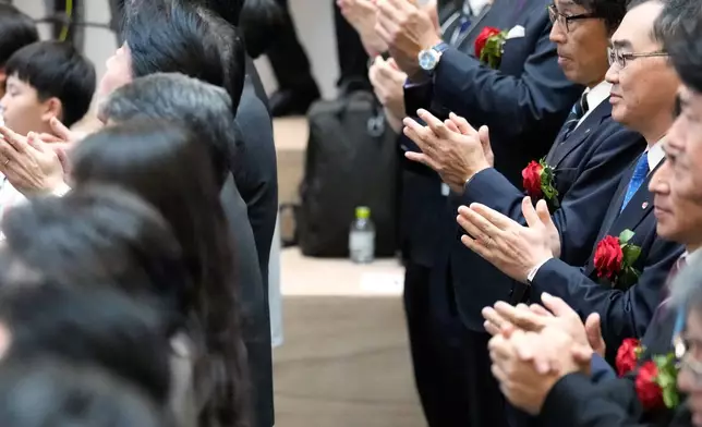 Participants perform a traditional hand clap at the end of a ceremony to conclude the year's trading at the Tokyo Stock Exchange Tuesday, Dec. 30, 2025, in Tokyo. (AP Photo/Eugene Hoshiko)
