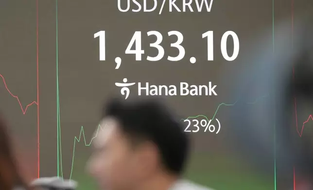 A dealer watches computer monitors near the screen showing the foreign exchange rate between U.S. dollar and South Korean won at a dealing room of Hana Bank in Seoul, South Korea, Tuesday, Dec. 30, 2025. (AP Photo/Lee Jin-man)