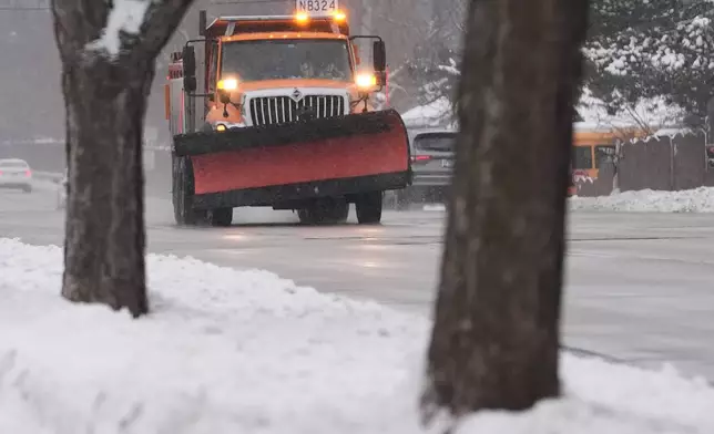 A snow plow truck drives during a snowy day in Wheeling, Ill., Monday, Dec. 1, 2025. (AP Photo/Nam Y. Huh)