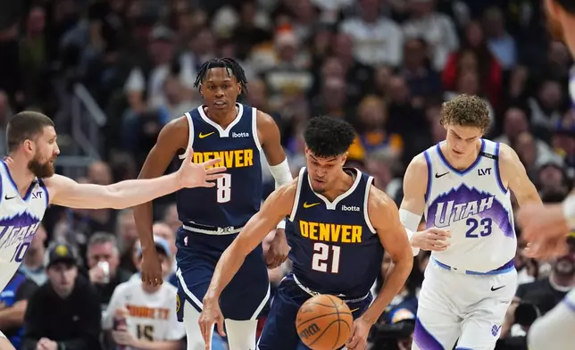 Denver Nuggets forward Spencer Jones, center, collects a loose ball as Utah Jazz forwards Svi Mykhailiuk, left, and Lauri Markkanen defend in the first half of an NBA basketball game Monday, Dec. 22, 2025, in Denver. (AP Photo/David Zalubowski)