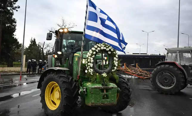 Farmers with their tractors try to block the main access road to Thessaloniki's international airport, northern Greece, Friday, Dec. 5, 2025, as protests over delays in European Union-backed agricultural subsidy payments escalated. (AP Photo/Giannis Papanikos)