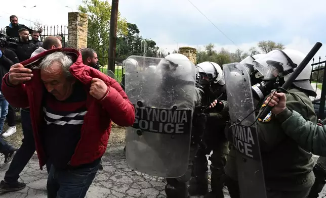 Riot police stop farmers trying to block the main access road to Thessaloniki's international airport, northern Greece, Friday, Dec. 5, 2025, as protests over delays in European Union-backed agricultural subsidy payments escalated. (AP Photo/Giannis Papanikos)