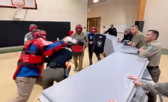 In this still image from video obtained by The Associated Press, Heather Sterling is hit in the head by one of her instructors, who is acting as a violent assailant, during a four-on-one training drill, Dec. 13, 2024, at the Texas Game Warden Training Center in Hamilton, Texas.