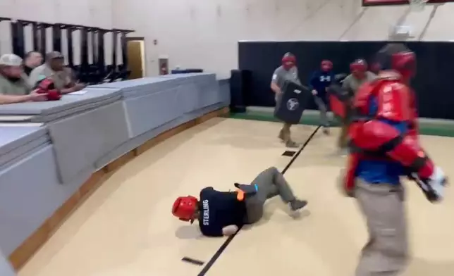 In this still image from video obtained by The Associated Press, Heather Sterling is knocked to the ground by one of her instructors, who is acting as a violent assailant, during a four-on-one training drill, Dec. 13, 2024, at the Texas Game Warden Training Center in Hamilton, Texas. (AP Photo)