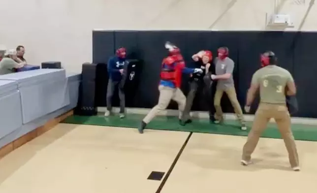 In this still image from video obtained by The Associated Press, Heather Sterling is hit by one of her instructors, who is acting as a violent assailant, during a four-on-one training drill, Dec. 13, 2024, at the Texas Game Warden Training Center in Hamilton, Texas.
