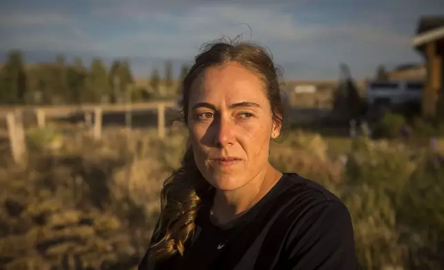 Heather Sterling watches her dog roam the yard at her home, Aug. 11, 2025, near Daniel, Wyo. (AP Photo/Amber Baesler)