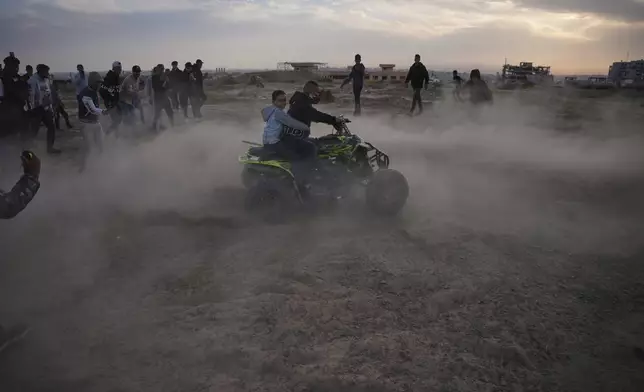 A young Palestinian man rides an ATV on a sand dune in the Al-Zahra area, in the central Gaza Strip, Friday, Dec. 5, 2025.(AP Photo/Abdel Kareem Hana)