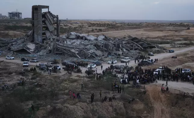 Palestinians watch youths riding their motorcycles on sand dunes in the Al-Zahra area, in the central Gaza Strip, Friday, Dec. 5, 2025. (AP Photo/Abdel Kareem Hana)