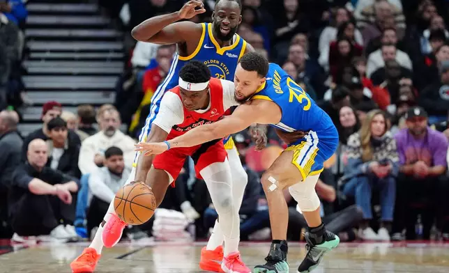 Toronto Raptors guard Ja'Kobe Walter, front left, tries to get the ball past Golden State Warriors guard Stephen Curry (30) and teammate Draymond Green, back left, during first-half NBA basketball game action in Toronto, Sunday, Dec. 28, 2025. (Frank Gunn/The Canadian Press via AP)