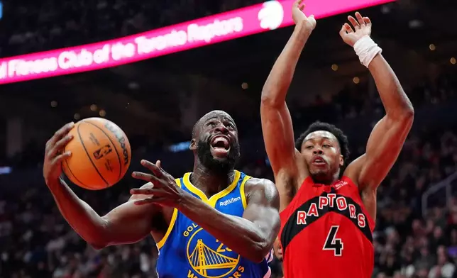 Golden State Warriors forward Draymond Green, left, drives to the net past Toronto Raptors forward Scottie Barnes (4) during first-half NBA basketball game action in Toronto, Sunday, Dec. 28, 2025. (Frank Gunn/The Canadian Press via AP)