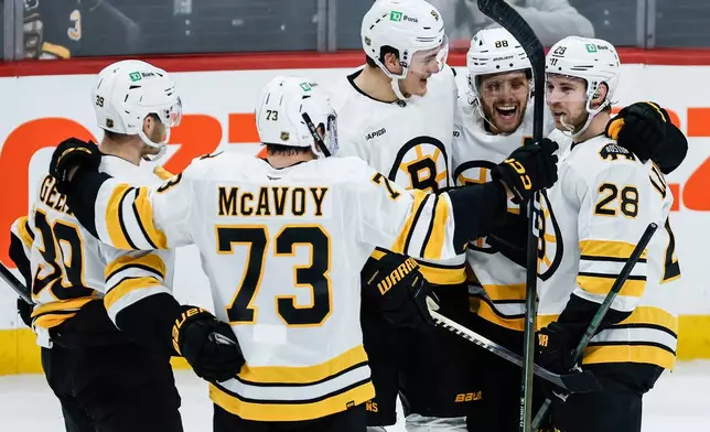 Boston Bruins players celebrate Elias Lindholm's (28) goal against the Winnipeg Jets during the third period of of an NHL hockey game, in Winnipeg, Manitoba, Thursday, Dec. 11, 2025. (John Woods/The Canadian Press via AP)