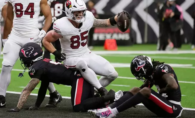 Arizona Cardinals tight end Trey McBride (85) celebrates a touchdown against Houston Texans safeties Jalen Pitre, left, and Calen Bullock, right, during the second half of an NFL football game Sunday, Dec. 14, 2025, in Houston. (AP Photo/Eric Christian Smith)