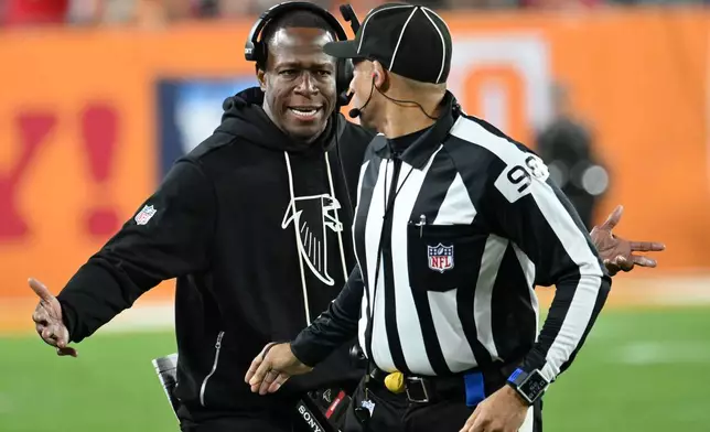 Atlanta Falcons head coach Raheem Morris speaks with line judge Greg Bradley during the second half of an NFL football game against the Tampa Bay Buccaneers, Thursday, Dec. 11, 2025, in Tampa, Fla. (AP Photo/Jason Behnken)