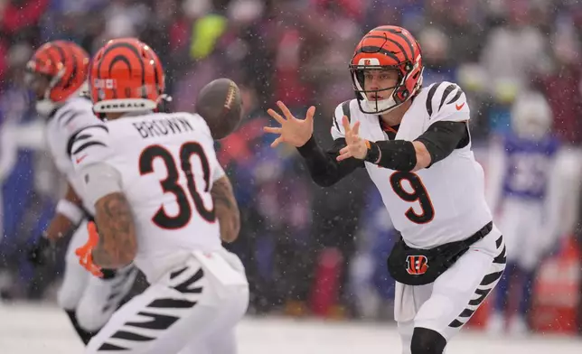 Cincinnati Bengals quarterback Joe Burrow (9) shovels the ball during the first half of an NFL football game against the Buffalo Bills, Sunday, Dec. 7, 2025, in Orchard Park, N.Y. (AP Photo/Gene J. Puskar)