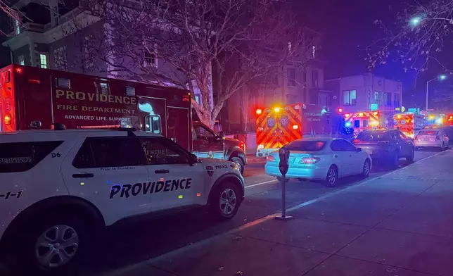 Police vehicles and first responders gather at Waterman St, and Thayer in response to a shooting, in Providence, R.I., Saturday, Dec. 13, 2025. (AP Photo/Jen McDermott)
