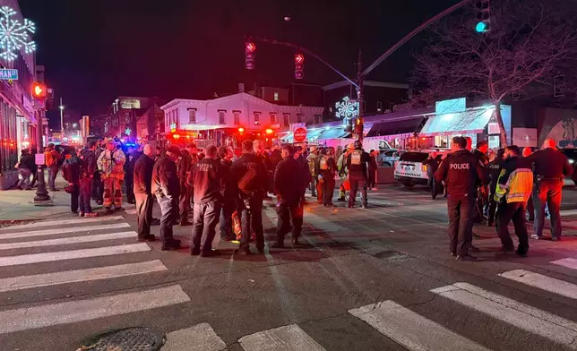 Police officers and first responders gather at Waterman St. and Thayer in response to a shooting, in Providence, R.I., Saturday, Dec. 13, 2025, . (AP Photo/Jen McDermott)