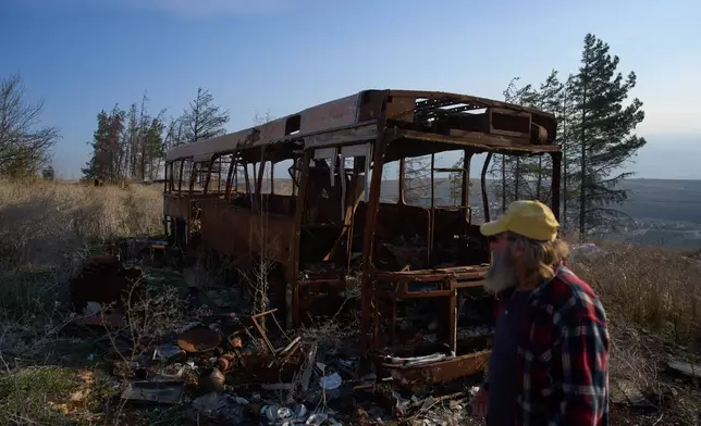 Ilan Rosenfeld walks through the burnt-out shell of his business in Israel's northernmost town of Metula, Sunday, Nov. 30, 2025. (AP Photo/Ariel Schalit)