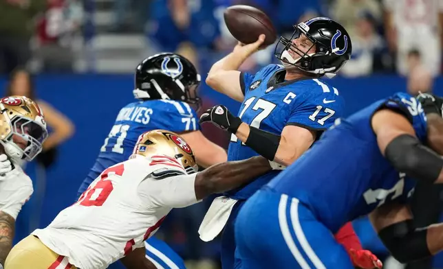 Indianapolis Colts quarterback Philip Rivers (17) passes while pressured by San Francisco 49ers defensive end Clelin Ferrell during the second half of an NFL football game, Monday, Dec. 22, 2025, in Indianapolis. (AP Photo/Carolyn Kaster)