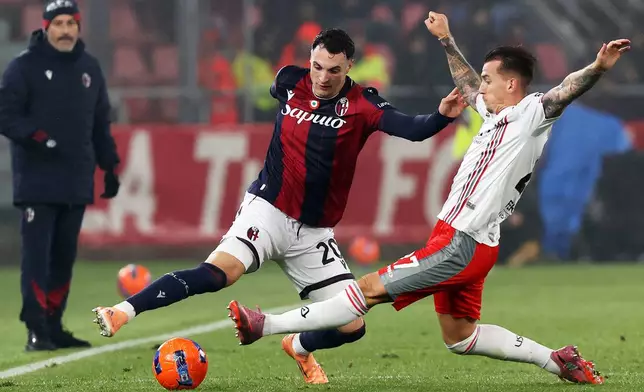 Cremonese's Jari Vandeputte, right, and Bologna's Nadir Zortea, left, challenge for the ball during the Serie A soccer match between FC Bologna and US Cremonese in Bologna, Italy, Monday, Dec. 1, 2025. (Gianni Santandrea/LaPresse via AP)