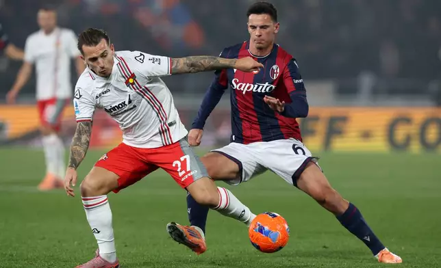 Cremonese's Jari Vandeputte, left, and Bologna's Nikola Moro, right, challenge for the ball during the Serie A soccer match between FC Bologna and US Cremonese in Bologna, Italy, Monday, Dec. 1, 2025. (Gianni Santandrea/LaPresse via AP)