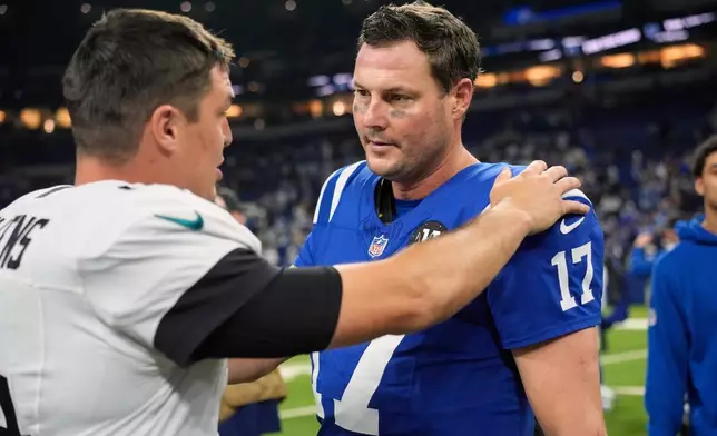 Jacksonville Jaguars quarterback Nick Mullens (14) talks with Indianapolis Colts quarterback Philip Rivers (17) following an NFL football game Sunday, Dec. 28, 2025, in Indianapolis. (AP Photo/Carolyn Kaster)