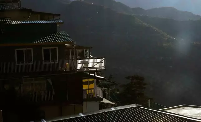 An exiled Tibetan cleans his balcony at Mcleodganj near Dharamshala, India, March 6, 2025. (AP Photo/Manish Swarup)