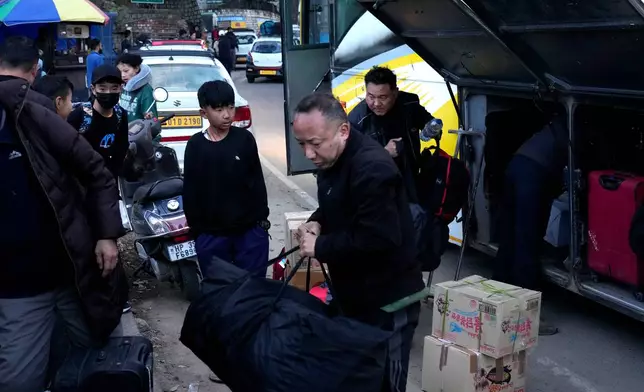 Sonam Tashi, right, and his son, Kunga Tenzin, take their luggage from a bus after reaching Dharamshala, India, where Tashi hopes the Tibetan government in exile can help his son access education, March 5, 2025. (AP Photo/Manish Swarup)