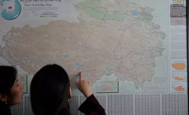 Namkyi, right, a Tibetan former political prisoner who was arrested at 15 for protesting Chinese rule, shows the route she took when she escaped and crossed into Nepal to Tsejin Khando, with the International Campaign for Tibet, Oct. 8, 2025, at the Office of Tibet in Washington. (AP Photo/David Goldman)