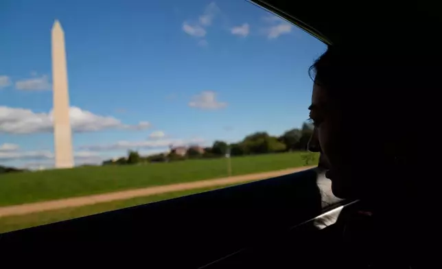 Namkyi, a Tibetan former political prisoner who was arrested at 15 for protesting Chinese rule, looks out toward the Washington Monument while driving to a meeting, Oct. 8, 2025, in Washington. (AP Photo/David Goldman)