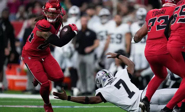 Houston Texans cornerback Derek Stingley Jr., left, returns an interception thrown by Las Vegas Raiders quarterback Geno Smith (7) for a touchdown during the first half of an NFL football game, Sunday, Dec. 21, 2025, in Houston. (AP Photo/Eric Christian Smith)