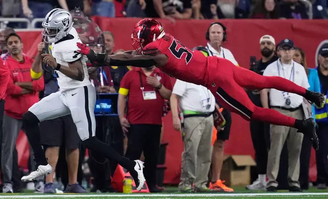 Las Vegas Raiders quarterback Geno Smith (7) runs against Houston Texans defensive end Danielle Hunter during the second half of an NFL football game, Sunday, Dec. 21, 2025, in Houston. (AP Photo/Ashley Landis)