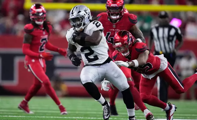 Las Vegas Raiders running back Ashton Jeanty, middle, runs past Houston Texans cornerback Myles Bryant, right, to score during the second half of an NFL football game, Sunday, Dec. 21, 2025, in Houston. (AP Photo/Ashley Landis)