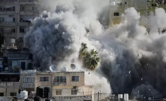 Smoke rises as Israeli forces demolish the home of Abdul Karim Sanoubar, a suspected Palestinian militant who has been accused by Israel of planting bombs on buses in central Israel, in Nablus, West Bank, Tuesday, Dec. 2, 2025. (AP Photo/Majdi Mohammed)
