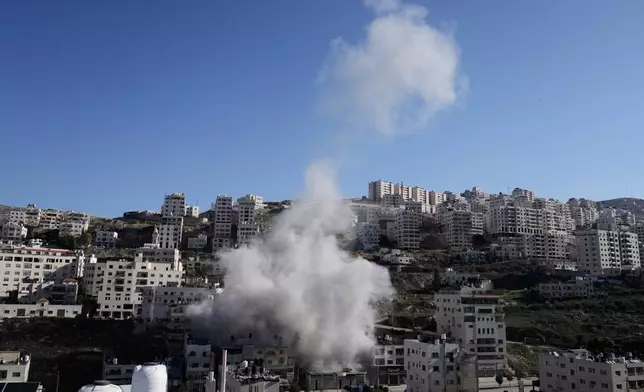 Smoke rises as Israeli forces demolish the home of Abdul Karim Sanoubar, a suspected Palestinian militant who has been accused by Israel of planting bombs on buses in central Israel, in Nablus, West Bank, Tuesday, Dec. 2, 2025. (AP Photo/Majdi Mohammed)
