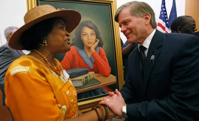 FILE - Joan Cobbs, left, sister of civil rights legend Barbara Johns, shakes hands with Virginia Gov. Bob McDonnell, right, after a portrait of Barbara Johns, center, was unveiled in the Virginia State Capitol in Richmond, Va., Sept. 17, 2010. (Bob Brown/Richmond Times-Dispatch via AP)