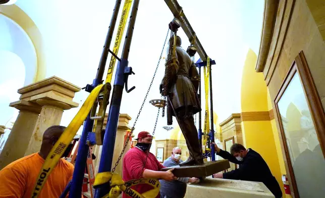FILE - This Monday, Dec. 21, 2020 photo provided by the Office of the Governor of Virginia shows workers removing a statue of Confederate Gen. Robert E. Lee from the National Statuary Hall Collection in Washington. (Jack Mayer/Office of Governor of Virginia, File)