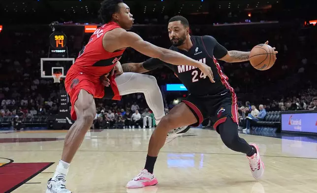 Miami Heat guard Norman Powell (24) drives to the basket as Toronto Raptors forward Scottie Barnes, left, defends during the first half of an NBA basketball game, Monday, Dec. 15, 2025, in Miami. (AP Photo/Lynne Sladky)