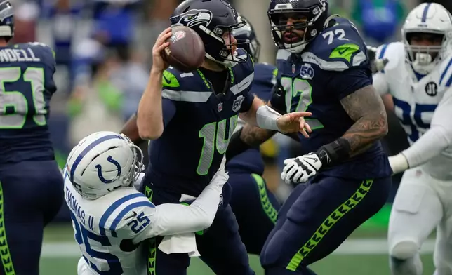 Seattle Seahawks quarterback Sam Darnold (14) tries to throw under pressure from Indianapolis Colts safety Rodney Thomas II (25) during the first half of an NFL football game Sunday, Dec. 14, 2025, in Seattle. (AP Photo/Stephen Brashear)