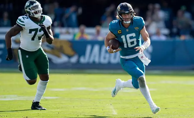 Jacksonville Jaguars quarterback Trevor Lawrence (16) runs with the ball against New York Jets defensive end Micheal Clemons (72) during the first half of an NFL football game, Sunday, Dec. 14, 2025, in Jacksonville, Fla. (AP Photo/John Raoux)