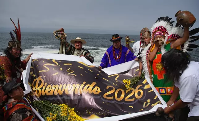 Shamans perform an annual ritual to predict political and social issues for the new year in Lima, Peru, Monday, Dec. 29, 2025. The sign reads in Spanish "Welcome 2026." (AP Photo/Guadalupe Pardo)