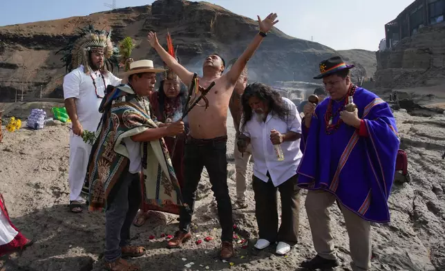 Shamans perform a personalized blessing for a man during their annual ritual to predict political and social issues for the new year, on the coast of Lima, Peru, Monday, Dec. 29, 2025. (AP Photo/Guadalupe Pardo)