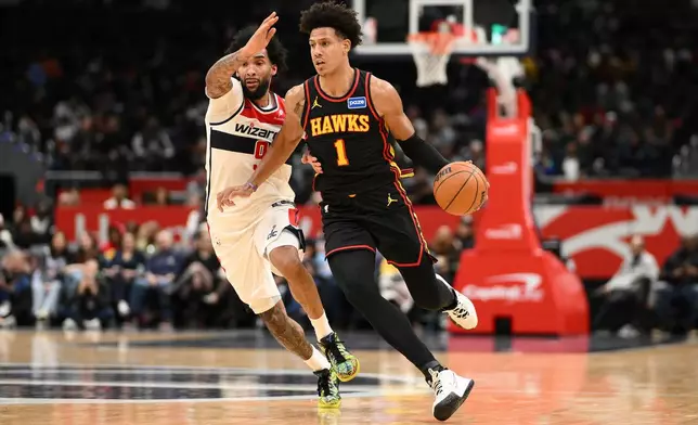 Atlanta Hawks forward Jalen Johnson (1) dribbles the ball against Washington Wizards forward Justin Champagnie, left, during the second half of an NBA basketball game, Saturday, Dec. 6, 2025, in Washington. (AP Photo/Nick Wass)