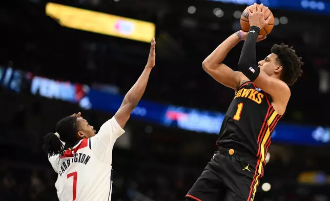 Atlanta Hawks forward Jalen Johnson (1) shoots against Washington Wizards guard Bub Carrington (7) during the second half of an NBA basketball game, Saturday, Dec. 6, 2025, in Washington. (AP Photo/Nick Wass)