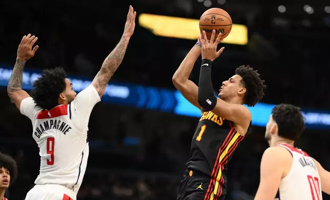 Atlanta Hawks forward Jalen Johnson (1) goes to the basket against Washington Wizards forwards Justin Champagnie (9) and Tristan Vukcevic (00) during the second half of an NBA basketball game, Saturday, Dec. 6, 2025, in Washington. (AP Photo/Nick Wass)