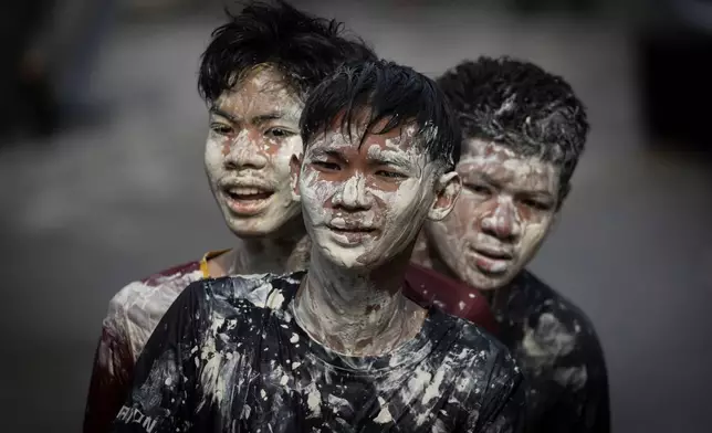 Young men don a powdery paste called din sor pong, believed to bring blessings and protection, as they take part in the Songkran water festival marking the Thai New Year in Prachinburi province, central Thailand, April 13, 2025. (AP Photo/Wason Wanichakorn, File)