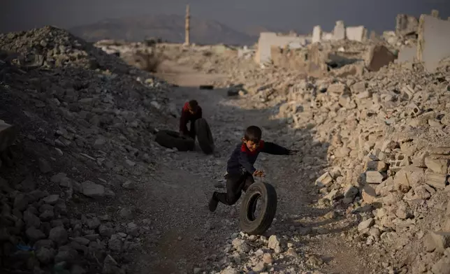 Kids play surrounded by rubble on an area of houses that were completely destroyed during the civil war at the Al-Asali neighbourhood in Damascus, Syria, Jan. 6, 2025. (AP Photo/Leo Correa, File)