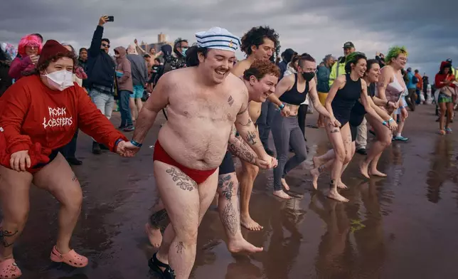 Revelers enter the cold water during the annual Polar Bear Plunge on New Year's Day, Jan. 1, 2025, in New York. (AP Photo/Andres Kudacki, File)