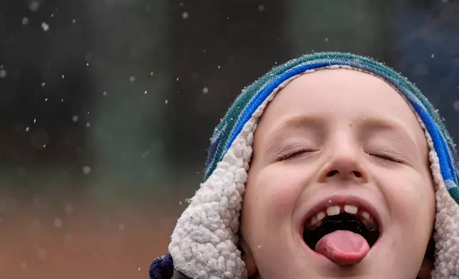 A child catches snowflakes with their tongue during El Museo del Barrio's 47th annual Three Kings Day parade, Jan. 6, 2025, in New York. (AP Photo/Julia Demaree Nikhinson, File)